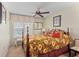 Cozy bedroom features a window with blinds, a ceiling fan, and warm decor at 3790 Pinebrook Cir # 408, Bradenton, FL 34209