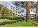 A multi-story condo building with a well-maintained lawn and mature trees and shrubs at 3790 Pinebrook Cir # 408, Bradenton, FL 34209