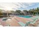 A sunny view of a community pool surrounded by lounge chairs and a spa at 3790 Pinebrook Cir # 408, Bradenton, FL 34209