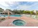 A community pool and spa surrounded by lounge chairs, seating, and palm trees at 3790 Pinebrook Cir # 408, Bradenton, FL 34209