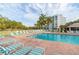 View of the community pool with lounge chairs and seating next to a condo building at 3790 Pinebrook Cir # 408, Bradenton, FL 34209