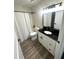 Clean bathroom with a black granite vanity, white cabinets, and shower with curtain at 4005 Crockers Lake Blvd # 11, Sarasota, FL 34238