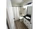 Bathroom view featuring a granite vanity, white shower curtain, and hardwood flooring at 4005 Crockers Lake Blvd # 11, Sarasota, FL 34238