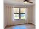 Bedroom featuring a ceiling fan, wood-look floors, and a window with neutral curtains at 4005 Crockers Lake Blvd # 11, Sarasota, FL 34238