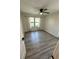Bright bedroom featuring a ceiling fan, wood-look floors, and a window with neutral curtains at 4005 Crockers Lake Blvd # 11, Sarasota, FL 34238