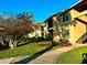 Condominium exterior showcasing lush landscaping, manicured lawn, and covered staircase under a clear sky at 4005 Crockers Lake Blvd # 11, Sarasota, FL 34238