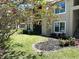 Tan condo building with lush green lawn and landscaping details in front of the screened in patio at 4005 Crockers Lake Blvd # 11, Sarasota, FL 34238
