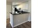 Bright kitchen with white cabinetry, black appliances and countertops, and hardwood floors at 4005 Crockers Lake Blvd # 11, Sarasota, FL 34238
