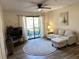 Living room with hardwood flooring, ceiling fan, and sliding glass door to outside patio at 4005 Crockers Lake Blvd # 11, Sarasota, FL 34238