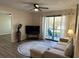 Living room with hardwood flooring, ceiling fan, and sliding glass door to outside patio at 4005 Crockers Lake Blvd # 11, Sarasota, FL 34238