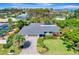Aerial view of a home with gray roof, showing driveway, lawn, landscaping, and tree coverage at 405 Park N Blvd, Venice, FL 34285