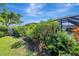 Backyard with manicured lawn, lush landscaping, mature tropical foliage and a screened lanai at 405 Park N Blvd, Venice, FL 34285