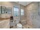 Bathroom featuring marble vanity, modern shower stall with bench, and ample natural light at 405 Park N Blvd, Venice, FL 34285
