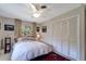 Comfortable bedroom featuring a ceiling fan, two windows, a closet with folding doors, and soft neutral decor at 405 Park N Blvd, Venice, FL 34285