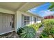 Charming home entrance featuring a decorative door, lush landscaping, and shuttered windows at 405 Park N Blvd, Venice, FL 34285