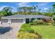 Charming single-story home with a well-manicured lawn, mature landscaping, and a two-car garage, creating a welcoming curb appeal at 405 Park N Blvd, Venice, FL 34285