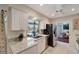 Well-lit kitchen featuring granite countertops, stainless steel appliances, and a view of the backyard and pool at 405 Park N Blvd, Venice, FL 34285