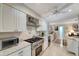 Modern kitchen with white cabinets, stainless steel appliances, and granite countertops, creating a clean and efficient cooking space at 405 Park N Blvd, Venice, FL 34285