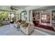 Bright Florida room with sliding glass doors to pool, casual furniture, and built-in bookshelves at 405 Park N Blvd, Venice, FL 34285