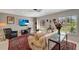 Stylish living room with a TV, shelving, and large windows, creating a bright and inviting space for relaxing and entertaining at 405 Park N Blvd, Venice, FL 34285