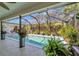 Enclosed pool area surrounded by tropical plants with a lounge area, perfect for entertaining at 405 Park N Blvd, Venice, FL 34285