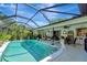 Relaxing screened-in pool area with ample seating, tropical plants, and an outdoor bar at 405 Park N Blvd, Venice, FL 34285