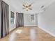 Light-filled bedroom featuring hardwood floors, neutral decor, and multiple windows with curtains at 4112 Swift Rd, Sarasota, FL 34231