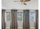 Bedroom showcasing multiple windows with long, flowing drapes and a ceiling fan at 4112 Swift Rd, Sarasota, FL 34231