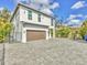 Wide driveway leading to a modern home with a prominent garage, set against a blue sky backdrop at 4112 Swift Rd, Sarasota, FL 34231