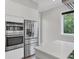 Modern kitchen featuring stainless steel appliances and sleek white cabinets, complemented by a bright window at 4112 Swift Rd, Sarasota, FL 34231