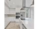 Contemporary kitchen with white cabinetry, modern appliances, and a central island featuring a sink and faucet at 4112 Swift Rd, Sarasota, FL 34231