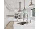 Sleek white kitchen boasting stainless steel appliances, a modern island, and a stylish range hood at 4112 Swift Rd, Sarasota, FL 34231
