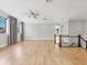 Large loft space featuring hardwood floors, a ceiling fan, multiple windows, and a glass-paneled banister at 4112 Swift Rd, Sarasota, FL 34231