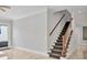 Interior staircase with wooden handrail, carpeted stairs, and tile flooring at 4112 Swift Rd, Sarasota, FL 34231