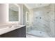 Bright bathroom features a glass shower with marble and a double sink vanity and custom lighted mirror at 4651 Gulf Of Mexico Dr # 304, Longboat Key, FL 34228