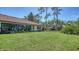 The backyard of this home has a luscious green lawn, landscaping, and mature trees at 5458 Golf Pointe Dr, Sarasota, FL 34243