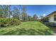 This luscious green lawn features landscaping, mature trees, and backs up to the home at 5458 Golf Pointe Dr, Sarasota, FL 34243