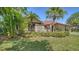 Exterior view of home featuring lush landscaping, a tiled roof, and a well-maintained lawn at 5458 Golf Pointe Dr, Sarasota, FL 34243