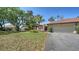 Inviting single-story home featuring a well-manicured lawn, mature trees, and a two-car garage at 5458 Golf Pointe Dr, Sarasota, FL 34243