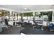 Bright fitness center featuring modern equipment, fans, rubber floors, and large windows showcasing the pool at 5458 Golf Pointe Dr, Sarasota, FL 34243