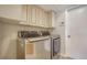 This laundry room has a new washer and dryer and white cabinets for storage at 5458 Golf Pointe Dr, Sarasota, FL 34243
