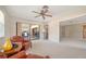 Bright living room features ceiling fan, neutral carpet, and sliding glass door to dining area at 5458 Golf Pointe Dr, Sarasota, FL 34243