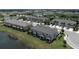 Aerial view of townhomes with garages, screened patios, and surrounded by lush landscaping and a pond at 5543 Pleasantview Ct, Bradenton, FL 34211