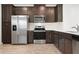 Modern kitchen with stainless steel appliances, dark wood cabinets, and stone countertops at 5543 Pleasantview Ct, Bradenton, FL 34211