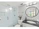Modern bathroom featuring a glass-enclosed shower, sleek fixtures, and an elegant round mirror at 5663 Midnight Pass Rd # 407, Sarasota, FL 34242