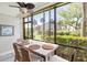 Cozy dining area with garden views through screened windows, a ceiling fan, and wicker chairs at 5663 Midnight Pass Rd # 407, Sarasota, FL 34242
