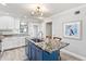 Modern kitchen with granite island, white cabinets, and stylish lighting at 5663 Midnight Pass Rd # 407, Sarasota, FL 34242