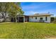 Large backyard with a screened-in lanai, a well-manicured lawn, and trees for shade at 5704 2Nd Avenue Nw Dr, Bradenton, FL 34209