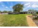 Large backyard featuring a spacious lawn, fire pit, and well-maintained landscaping at 5704 2Nd Avenue Nw Dr, Bradenton, FL 34209
