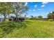 Expansive backyard with lush green grass, mature trees, firepit, and screened in lanai for outdoor living at 5704 2Nd Avenue Nw Dr, Bradenton, FL 34209